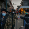 Китайската полиция мери температурата на граждани на временно поставен вход към търговски район в Пекин на 11 март 2020 г. (Кевин Фрейър/ Getty Images)