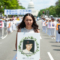 Жена държи снимка на мъж, убит в преследването срещу Фалун Гонг, инициирано от китайския режим, Вашингтон, 17 юли 2014 г. (Larry Dye/ „Епок Таймс“)