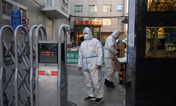 Охранители в защитна униформа пред входа на ресторант в Пекин, Китай, 04.03.2020 г. (Грег Бейкър/AFP)