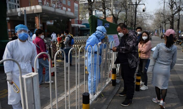 Болничен порсонал (вляво) регистрира пациенти на тротоара пред детска болница в Пекин на 31 март 2020 г. (Грег Бейкър/AFP чрез Getty Images)