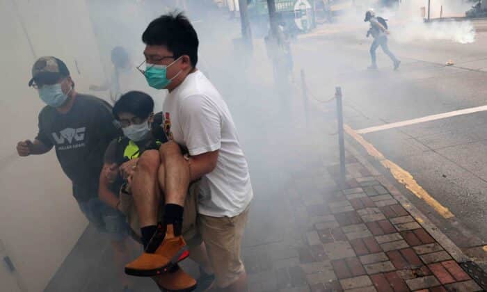 Демонстранти бягат от сълзотворен газ по време на протест на 24 май 2020 г. срещу плановете на Пекин да за налагане на закон за националната сигурност в Хонконг. (Tyrone Siu/Ройтерс)