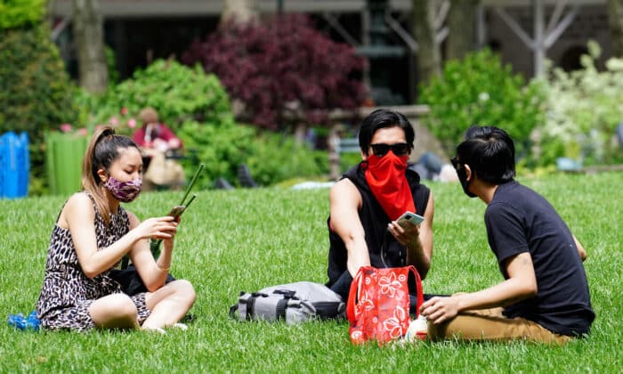 Трима души носят предпазни маски на поляна в „Брайънт парк“ в Ню Йорк на 22 май 2020 г. (Синди Орд/Getty Images)