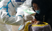 Медицинско лице прави на новородено тест за наличие на COVID – 19 в Шъдзяджуан, провинция Хъбей, Китай, 07.01.2021 г. (STR/CNS/AFP via Getty Images)