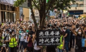 Протестиращи в Хонконг скандират по време на демонстрация срещу новия закон за националната сигурност на 1 юли - 23 години след предаването на Хонконг от Великобритания на Китай. Същия ден полицията за първи път арестува хора според този закон и използва водни оръдия срещу демонстрантите  (Снимка: Дейл де ла Рей / AFP)