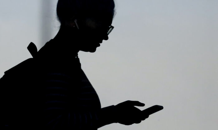 Жена си проверява телефона в Орем, щата Юта на 14 ноември 2019 г. (Рик Боумър/снимка АП)