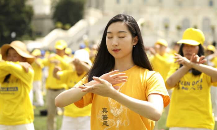 Фалун Гонг практикуващи изпълняват бавните медитативни упражнения на поляната пред Капитолия на 18 юли 2019 г., по време на събитие по повод 20-та годишнина от началото на преследването в Китай. (Самира Боуаоу/ Епок таймс)