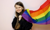 Момиче със знаме в цветовете на дъгата, превърнало се в символ на ЛГБТК+ обществата и техните протести за права (снимка: Katie Gerrard, unsplash.com)