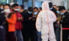 Охранител блокира изход, докато насочва хората да сканират QR код със здравословния им статус на гара Хончао в Шанхай, след нови случаи на COVID-19 в Шанхай, Китай, на 25 ноември 2021 г. . (Али Сонг/Ройтерс)