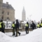 Полицейски служители минават покрай парламентарните сгради в Отава на 20 февруари 2022 г. (The Canadian Press/Adrian Wyld)