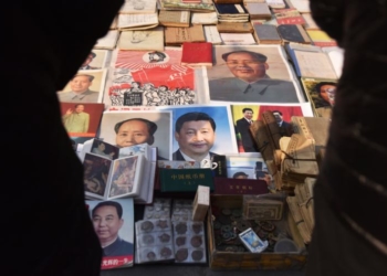 Постери на китайския лидер Си Дзинпин и на покойния комунистически лидер Мао Дзедун (в средата, и горе) на пазар в Пекин, 26 февруари 2018 г. (Грег Бейкър/AFP via Getty Images)