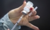 Човек вади ваксина Moderna, Колежа "Сейнт Лорънс" в Кингстън, Онтарио, на 2 януари 2022 г. (The Canadian Press/Lars Hagberg)