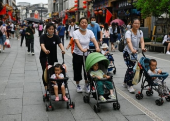 Майки с детски колички по бизнес улица в Пекин, 13 юли 2021 г. (Wang Zhao/AFP via Getty Images)