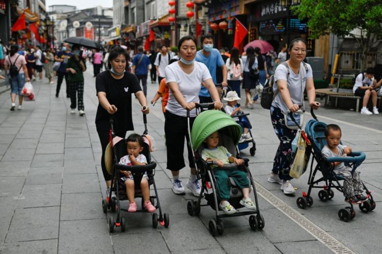 Майки с детски колички по бизнес улица в Пекин, 13 юли 2021 г. (Wang Zhao/AFP via Getty Images)