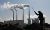 Работник реже тръби близо до въглищна електроцентрала в провинция Хъбей (Грег Бейкър/Getty Images)