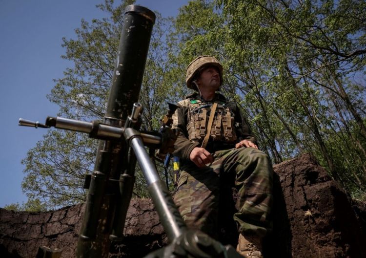 Украински военнослужещ се подготвя да стреля с миномет край град Бахмут (София Гатилова/Reuters)