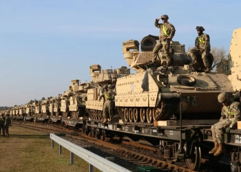 Военнослужещи на САЩ разтоварват тежко бойно оборудване, включително танкове "Ейбрамс" и бойни машини "Брадли", на железопътната гара край Пабраде в Литва (Petras Malukas/AFP via Getty Images)