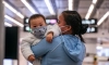 Майка с бебе със защитни маски на високоскоростната железопътна гара в Хонконг, 29 януари 2020 г. (Anthony Kwan/Getty Images)