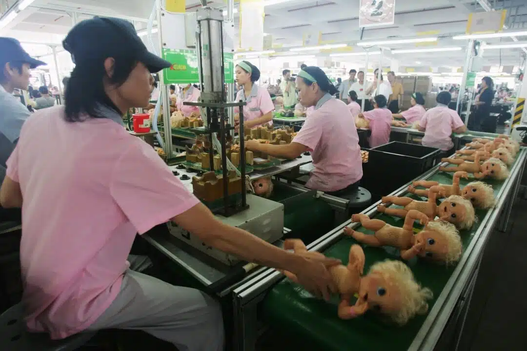 Работници сглобяват кукли на производствена линия в Гуандун, Китай, 4 септември 2007 г. (Фън Ли/Getty Images)