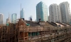 Работници ремонтират покрива на жилищна сграда в Шанхай, Китай (Johannes Eisele/AFP via Getty Images)