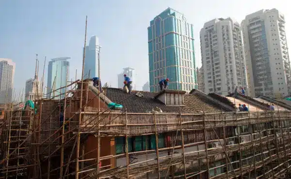 Работници ремонтират покрива на жилищна сграда в Шанхай, Китай (Johannes Eisele/AFP via Getty Images)