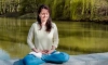 Natalya Minenkova does the Falun Gong meditation in Dendropark in Moscow, Russia, on July 5, 2022. (The Epoch Times)