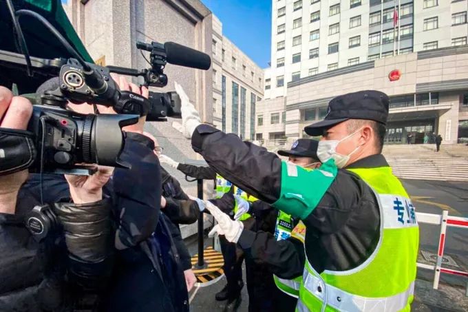 Полицай покрива медийна камера, за да попречи на журналистите да снимат пред новия Народен съд на район Пудун в Шанхай, където е насрочен процесът срещу китайската гражданска журналистка Джан Джан, 28 декември 2020 г. (Лео Рамирез /AFP via Getty Images)
