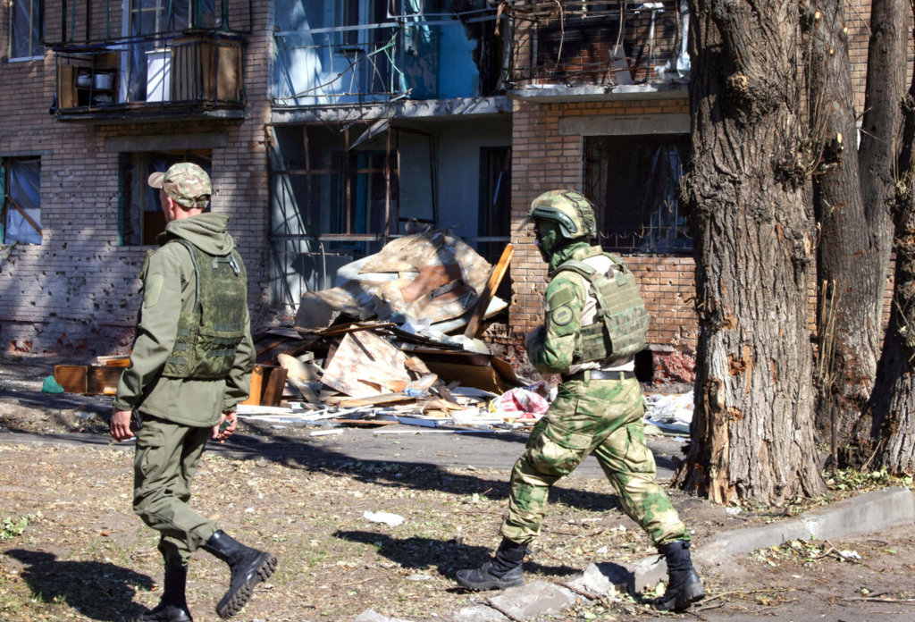 Местни доброволци минават покрай сграда, повредена от украински удари в Курск, Русия, на 16 август 2024 г. (Татяна Макеева/AFP чрез Getty Images)