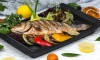 roasted fish garnished with lemon slices served with vegetables