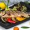 roasted fish garnished with lemon slices served with vegetables