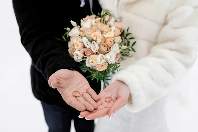 bride groom hold wedding rings their palms without face