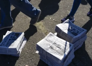 Купища вестници лежат на земята, докато хората пристигат за предизборен митинг организиран от Доналд Тръмп в Бътлър,  щата Пенсилвания, 5 октомври 2024 г. (AP Photo/Julia Demaree Nikhinson)