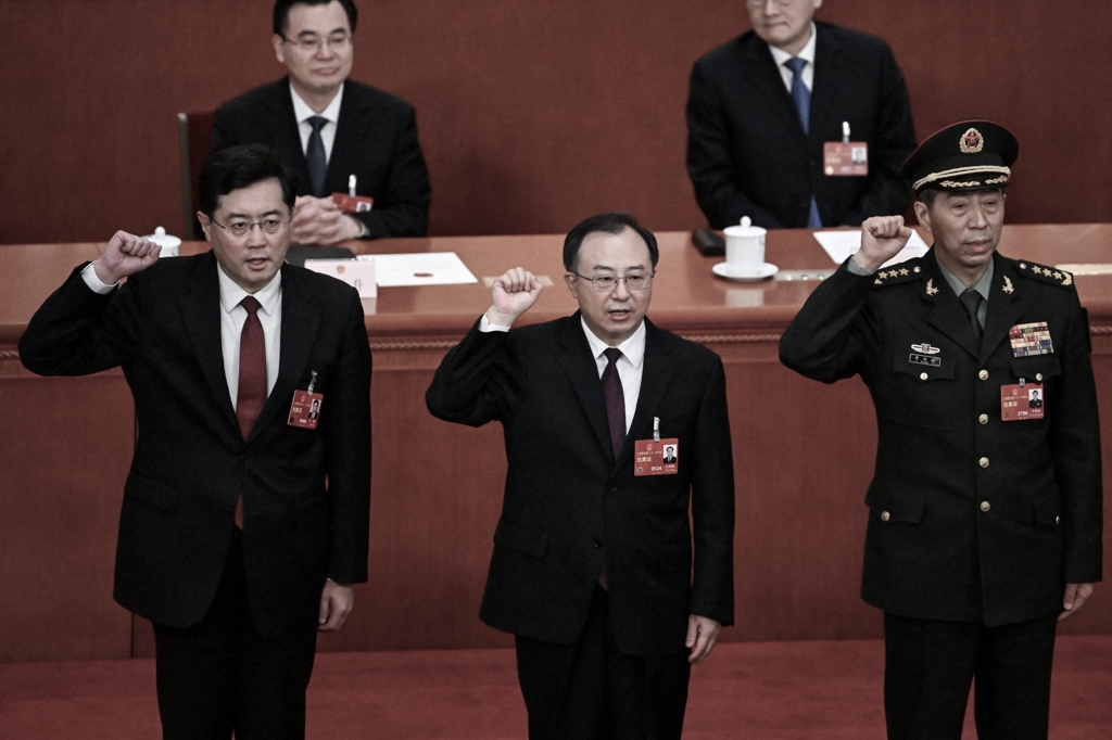 (L-R) Newly-elected Chinese state councilor Qin Gang, state councilor and secretary-general of the State Council Wu Zhenglong, state councilor Li Shangfu swear an oath after they were elected during the fifth plenary session of China's rubber-stamp legislature, the National People's Congress, at the Great Hall of the People in Beijing on March 12, 2023. (Noel Celis/AFP via Getty Images)