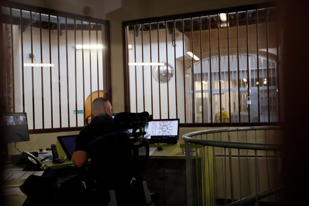Охранител от затворническата служба проверява защитните екрани на входа на затвора La Sante по време на посещение за пресата след четиригодишен проект за обновяване в Париж на 12 април 2019 г. (AP Photo/Francois Mori, File)