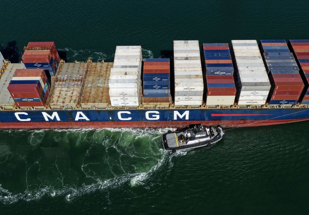 Контейнеровоз се подпомага от влекач при пристигането си в пристанището на Оукланд на 10 октомври 2025 г. (Justin Sullivan/Getty Images)