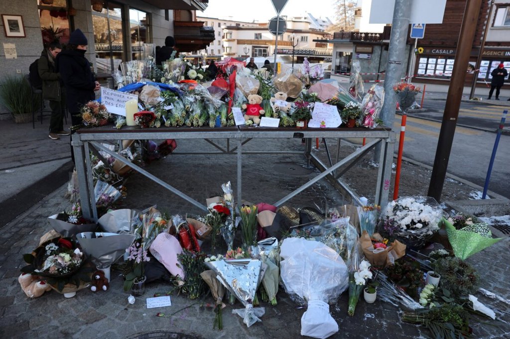 Швейцарски прокурор заяви, че искри от фойерверки върху шампанско вероятно са предизвикали смъртоносния пожар в бара 3 Цветни поклонения и плюшени мечета пред бар "Le Constellation" в Кранс-Монтана, Швейцария, на 2 януари 2026 г. (Stephanie Lecocq/Reuters)