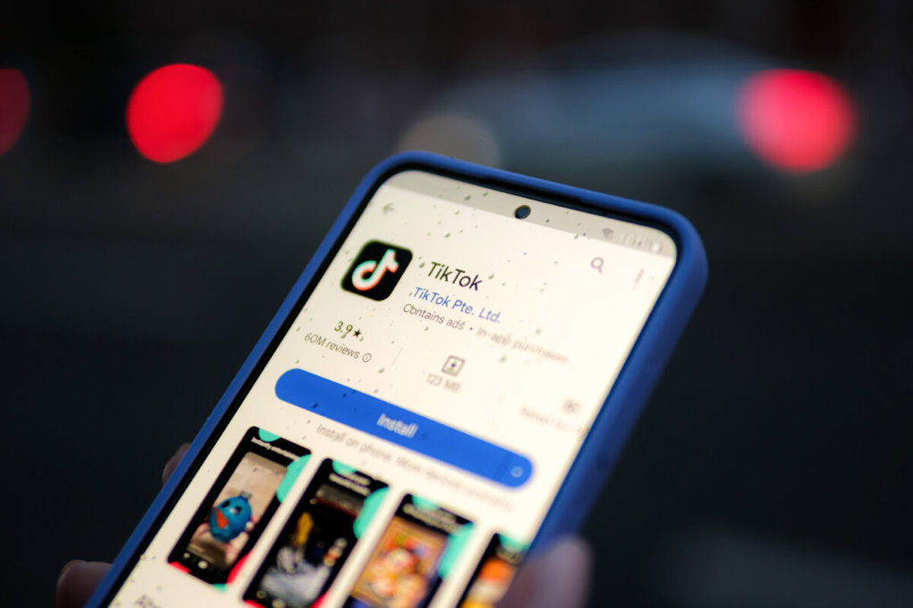 Британският регулатор откри разследване срещу TikTok заради безопасността на децата и проверките за възраст 2 Жена държи телефон с отворено приложение TikTok на 11 август 2024 г. (Oleksii Pydsosonnii/The Epoch Times)