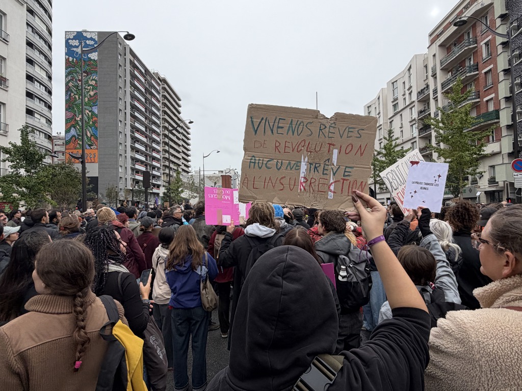 Френските протести отново прераснаха в насилие, но масираното полицейско присъствие ограничи грабежите 23 Протестиращ държи плакат с надпис „Да живеят мечтите ни за революция, никакво примирие за въстанието“ по време на демонстрация в Париж на 24 октомври 2026 г., на фона на крайнолеви протести в цяла Франция заради нарастващите разходи за живот и съкращенията на финансирането за образование. (Etienne Fauchaire/The Epoch Times)